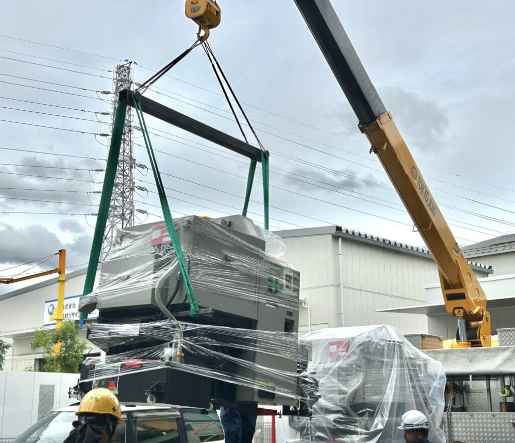 クレーンで持ち上がっている機械